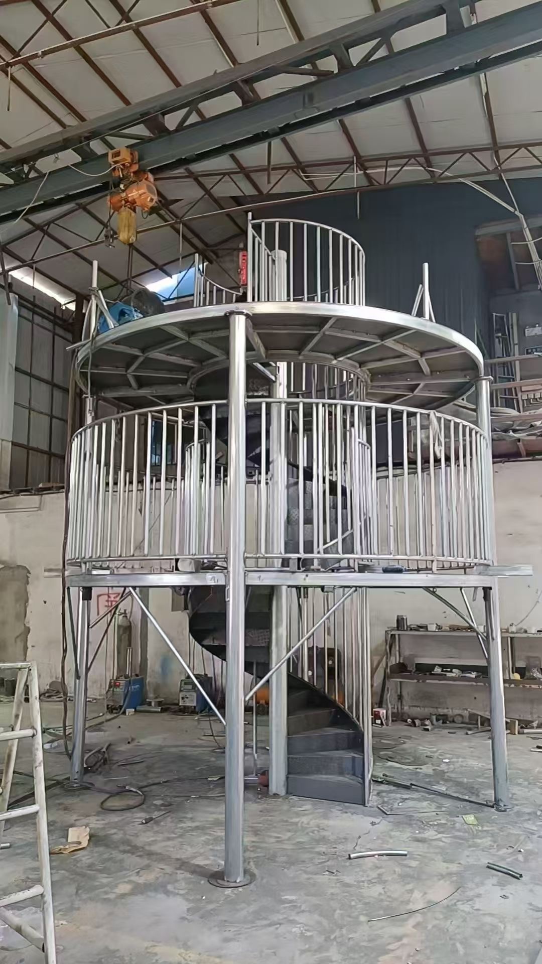 Manufacturing spiral play tower from galvanized steel Factory-fabricated spiral slide tower under construction