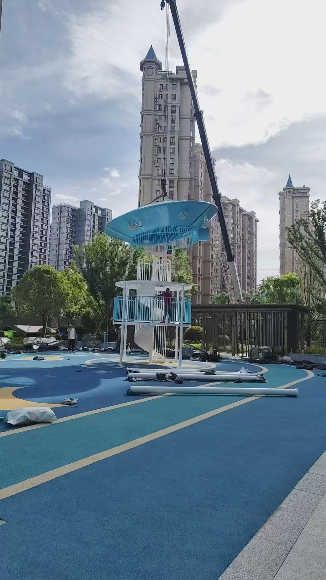 Installation phase with modular parts on-site Technicians preparing steel tube frame for playground