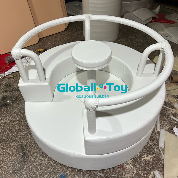 White circular indoor soft play carousel with secure seating for kids amusement center