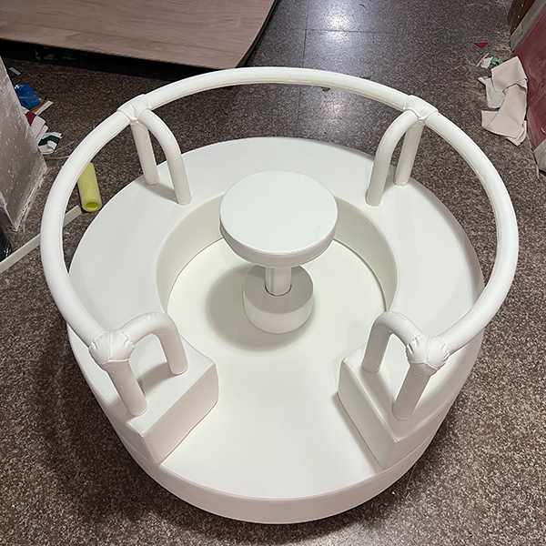 White indoor soft play roundabout toy for toddlers.