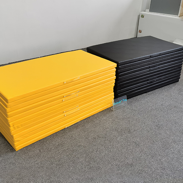 Stacked yellow and black soft play mats for kids zone