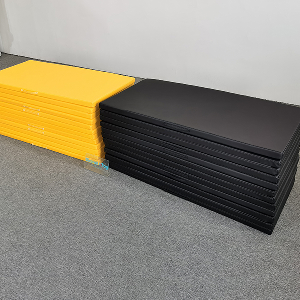 Foldable yellow foam mats stacked for indoor play area