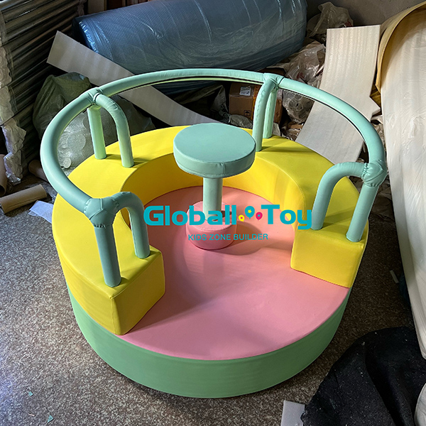 Indoor soft play merry go round for kids in pastel green pink and yellow