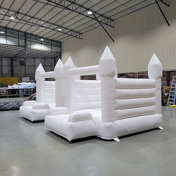 Dual white inflatable jumper castle setup for weddings
