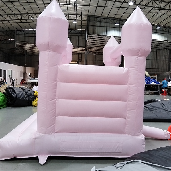 Roze opblaasbaar springhuis met vier torens voor kinderen