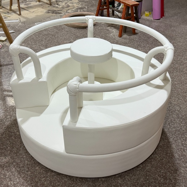 White soft play roundabout with handles for indoor playground