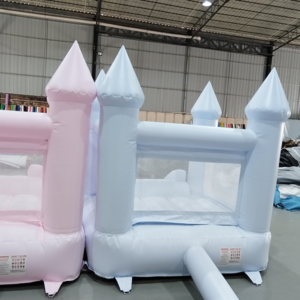 Maison de rebond pastel commercial avec glissade pour les enfants.