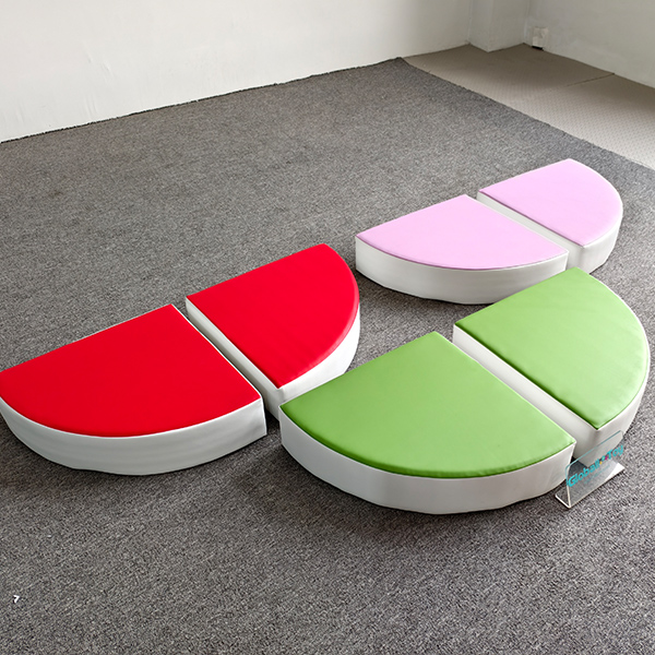 Fruit-shaped soft cushion playmat in red, green, and pink for indoor kids' play areas