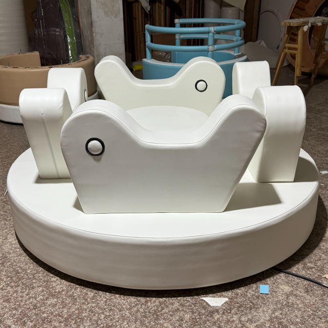 White soft play merry go round with steering wheel for kids indoor playground