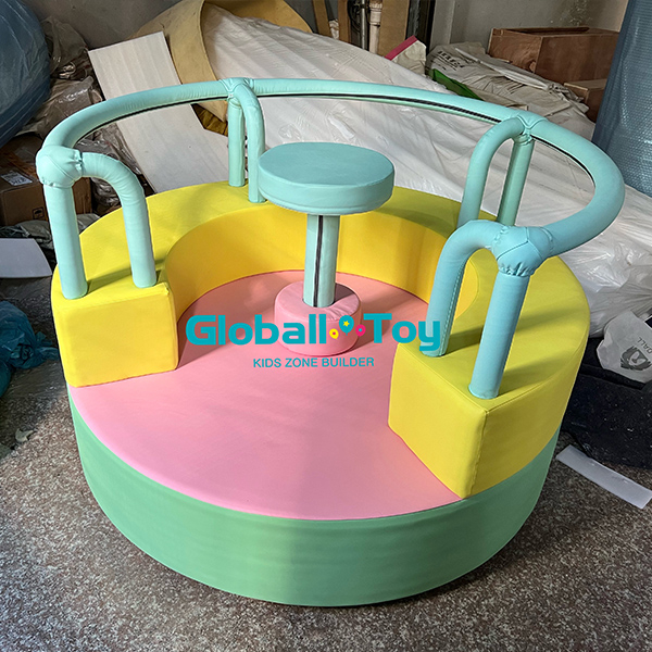 Soft play spinning ride for toddlers with colorful seats and central platform