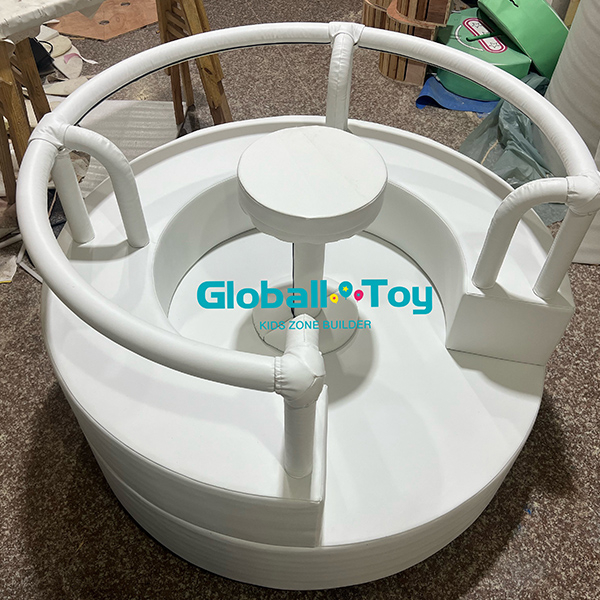 Soft play roundabout ride with padded seats and safety rail for toddlers indoor play
