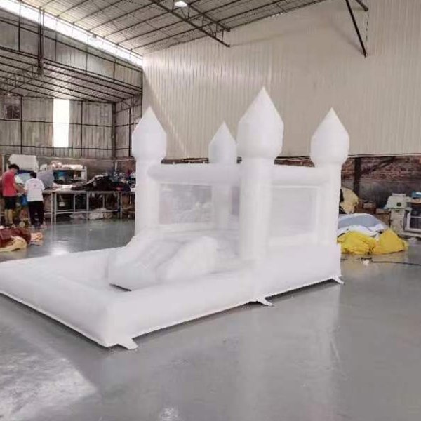 Castello gonfiabile bianco con scivolo per bambini e divertimento nel cortile